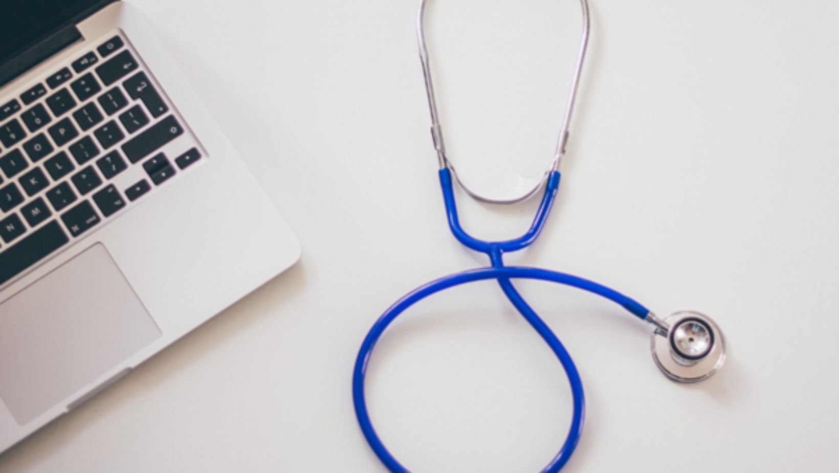 laptop-and-stethoscope-on-desk-symbolising-digital-research-when-choosing-orthopaedic-doctor